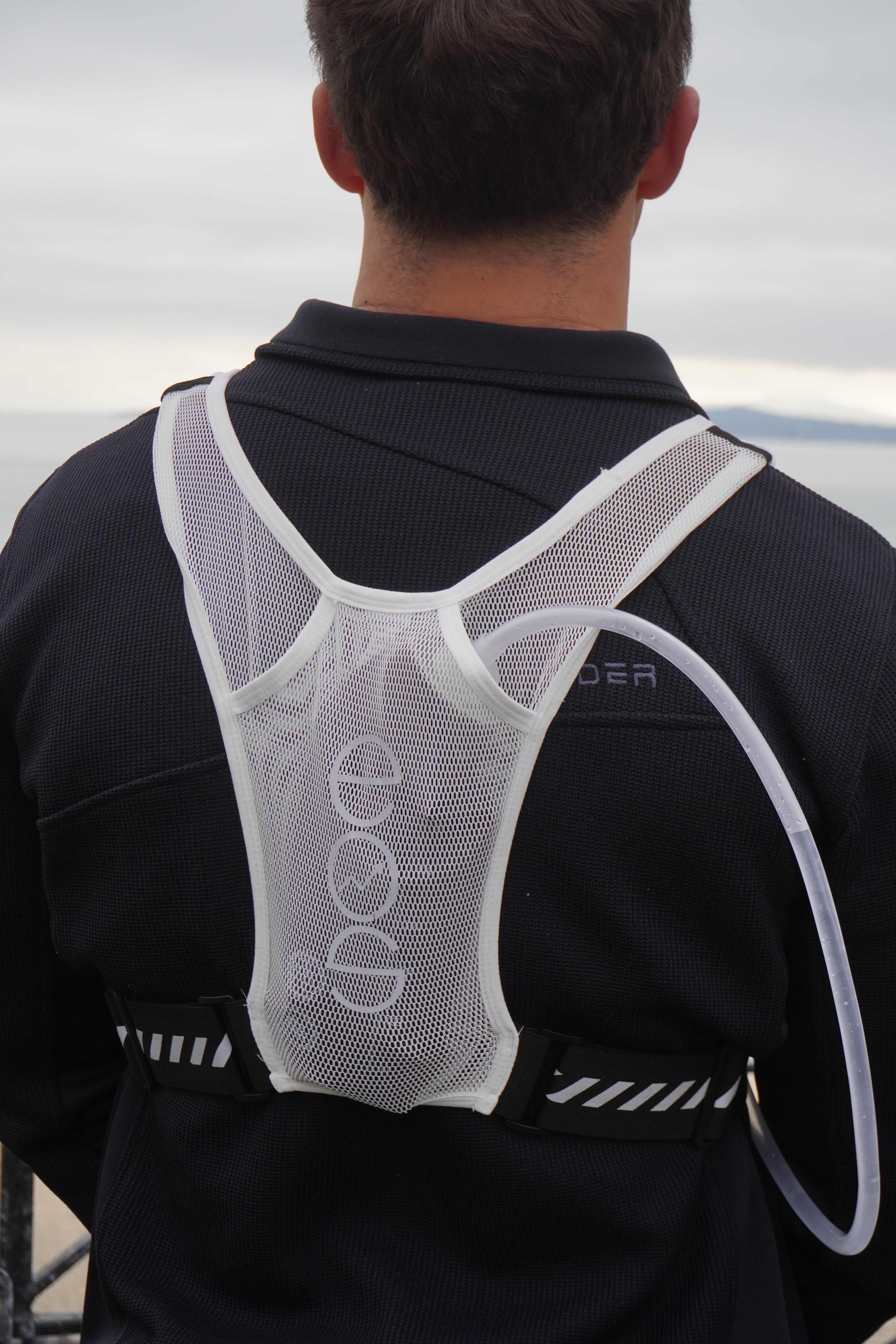 The Eos Elite water bladder is shown tucked into the back panel of the Eos Elite running best in white