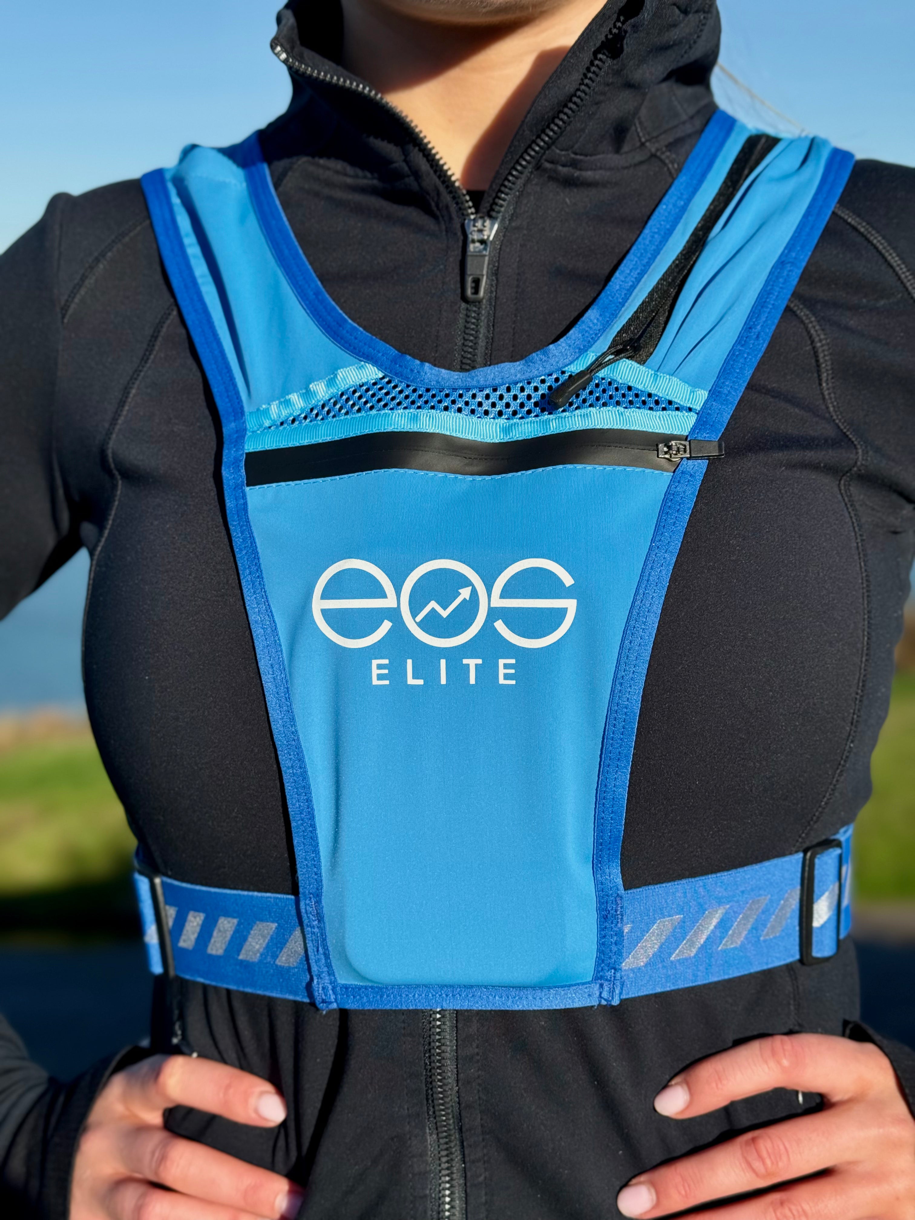 Eos Elite brand ambassador Erica Deasy is photographed wearing the blue Eos Elite RainGuard running best. The large front phone pocket, strap pocket and adjustable straps are clearly visible